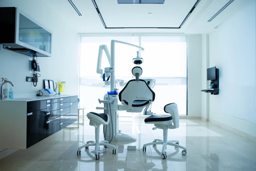 أفضل دكتور علاج عصب أسنان في جدة — دليل تام دنتال الشامل عيادة أسنان حديثة ومجهزة بالكامل، تحتوي على كرسي طبيب الأسنان وأدوات العلاج، مع إضاءة طبيعية كبيرة من نافذة خلفية، وبيئة نظيفة ومعقمة مخصصة لفحص وعلاج المرضى.