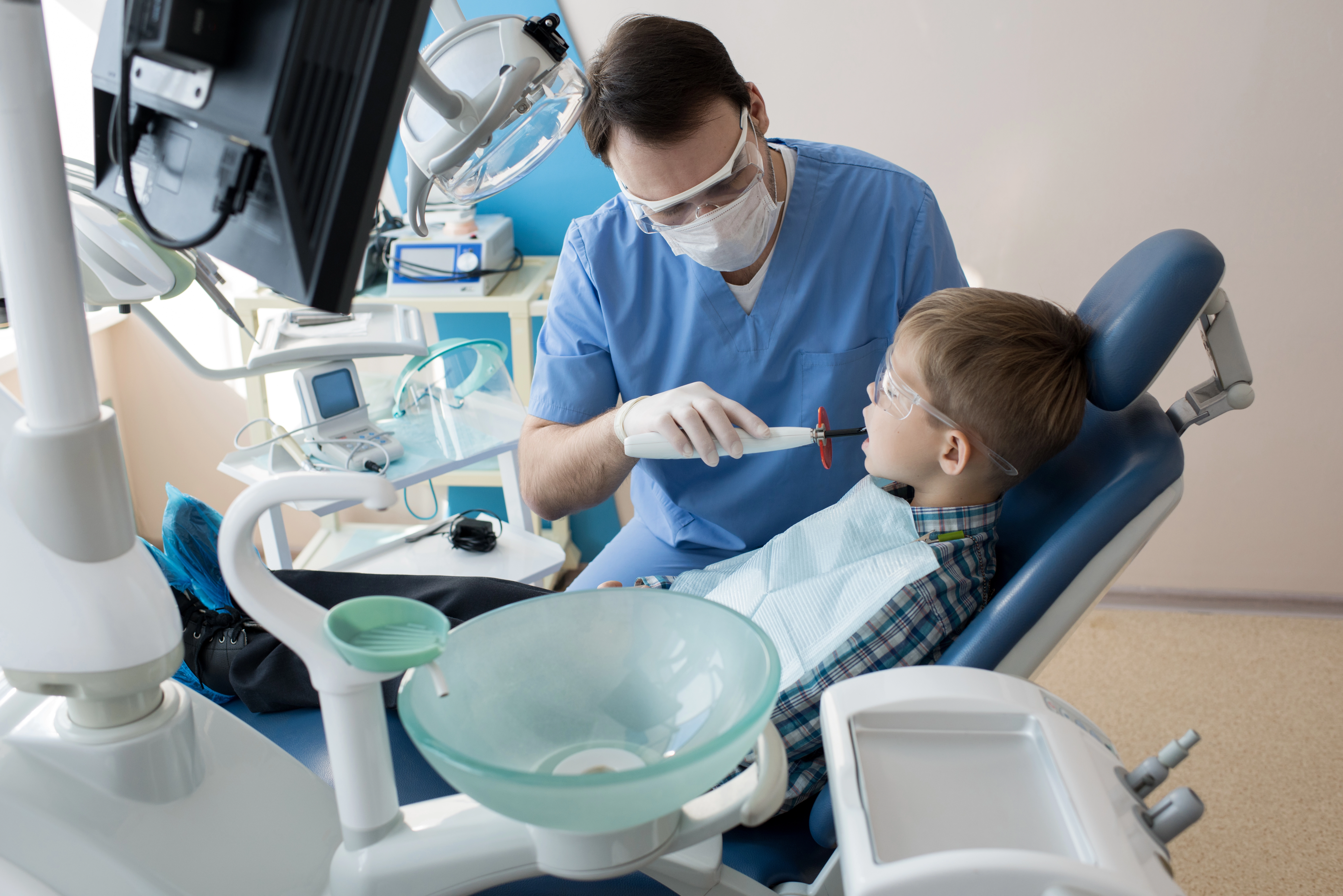 علاج أسنان الأطفال في جدة — دليل شامل لحماية ابتسامة طفلك طبيب أسنان يفحص أسنان طفل داخل عيادة حديثة خلال فحص دوري.