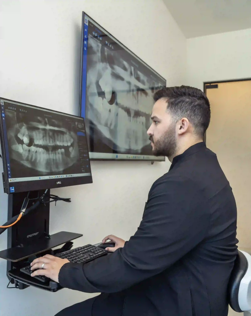 Dentist examining a wisdom tooth X-ray to assess the cause of wisdom tooth pain.