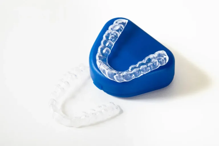 Clear aligners resting on a blue case.